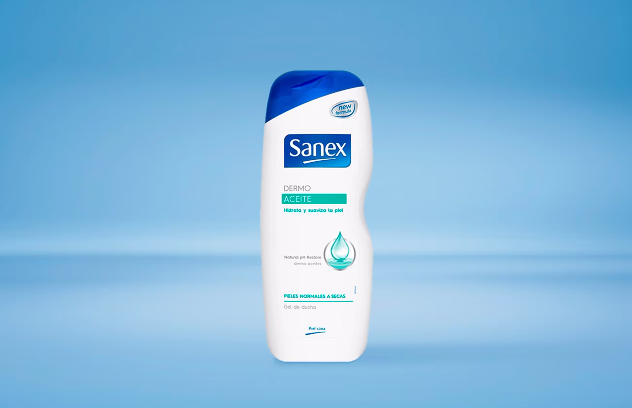 Een fles Sanex Dermo Aceite douchegel voor de normale tot droge huid, tegen een lichtblauwe achtergrond.